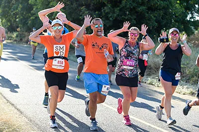Runners on the American River Parkway with their arms up
